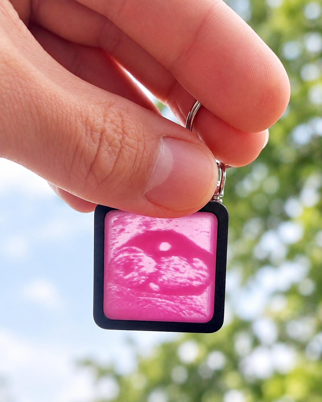 Gender-Reveal-Anhänger in rosa im Sonnenlicht